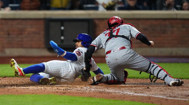 New York Mets' Francisco Lindor, left, slides past Minnesota Twins catcher Victor Caratini to score on a double by Francisco Alvarez during the fourth inning of a baseball game Wednesday, April 22, 2026, in New York. (AP Photo/Frank Franklin II)