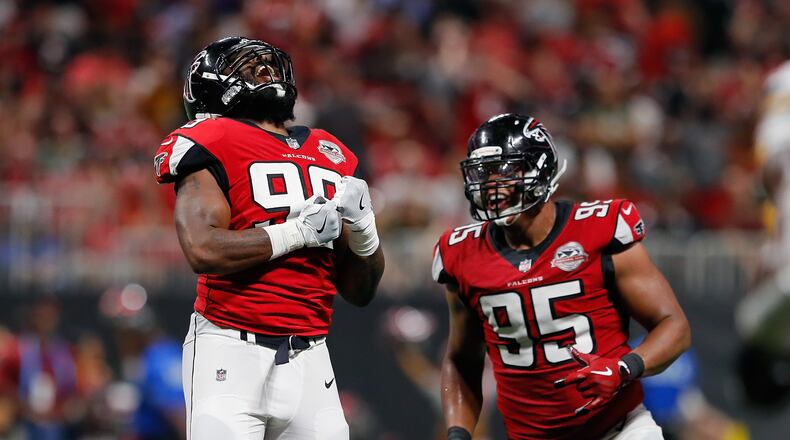 Adrian Clayborn #99 celebrates with Jack Crawford of the Falcons after sacking Aaron Rodgers of the Packers (not pictured) during the second half at Mercedes-Benz Stadium on September 17 in Atlanta.