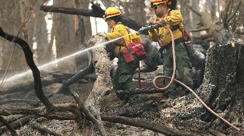 Firefighters from New Mexico put out hot spots at the Rock Mountain fire along Old Coleman River Road. Roswell fire officials say a total outdoor burn ban in the city is possible if the drought worsens or residents are careless with their fires. CURTIS COMPTON / CCOMPTON@AJC.COM