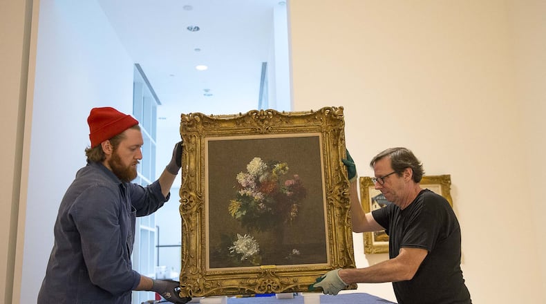 High Museum of Art chief preparer Brian Kelly (right) and Bonsai Fine Art museum preparer Seth Dalton (left) handle a Henri Fantin-Latour painting inside the Doris and Shouky Shaheen gallery at the High Museum of Art. (Alyssa Pointer/Atlanta Journal Constitution)