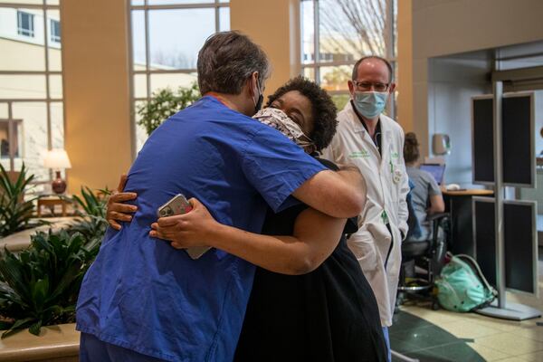 Radiologist Matthew McClain embraces Josetta Cooke at Floyd Medical Center in Rome earlier this week. McClain helped to diagnose Cooke one year ago, a diagnosis that made her the first known hospital case of COVID-19 in Georgia. (Alyssa Pointer / Alyssa.Pointer@ajc.com)
