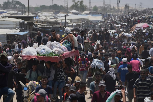 Palestinians carry bags containing food and humanitarian aid packages delivered by the Gaza Humanitarian Foundation, a U.S.-backed organization, in Rafah, southern Gaza Strip, Tuesday, June 10, 2025. (AP Photo/Abdel Kareem Hana)