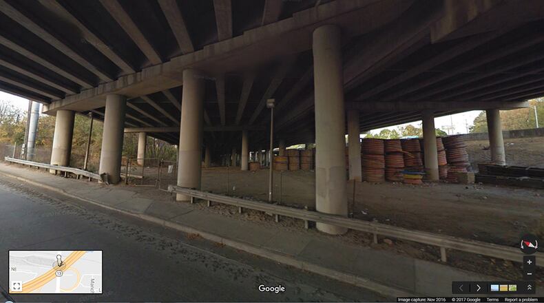 NOVEMBER 2016: This image from Google Maps Street View shows the underneath of I-85 where the interstate passes over Piedmont Road, looking to the northeast. The section that collapsed is above the stacked coils of material seen at right. (Google Maps Street View)