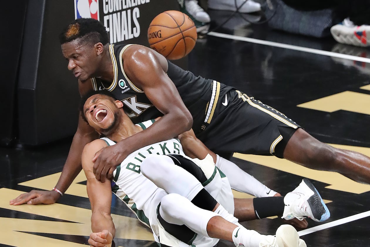 062921 Atlanta: Atlanta Hawks center Clint Capela and Milwaukee Bucks forward Giannis Antetokounmpo fall to the hardwood after battling at the basket with Giannis Antetokounmpo leaving the game with an apparent injury during the third quarter in game 4 of the NBA Eastern Conference Finals on Tuesday, June 29, 2021, in Atlanta. “Curtis Compton / Curtis.Compton@ajc.com”