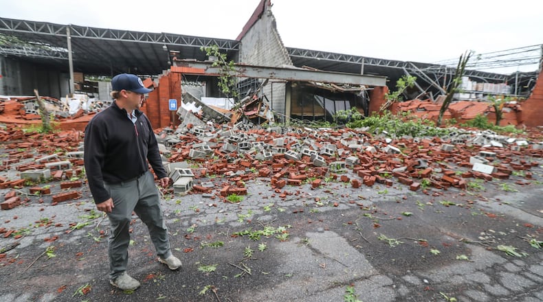 Dru Ghegan surveys the damage to his Fulton County business Tuesday after a severe storm rolled through the area.