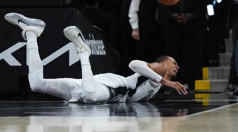 San Antonio Spurs forward Victor Wembanyama (1) takes a hard fall on the court during the first half in Game 2 of a first-round NBA playoffs basketball series against the Portland Trail Blazers in San Antonio, Tuesday, April 21, 2026. (AP Photo/Eric Gay)