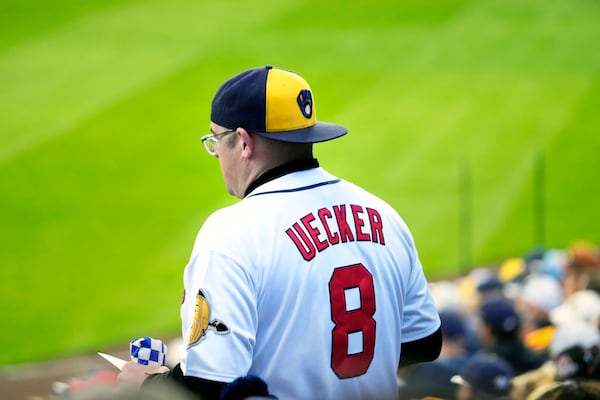 A Milwaukee Brewers fan wears a Bob Uecker jersey as he walks to his seat during the first inning of a baseball game Monday, March 31, 2025, in Milwaukee. (AP Photo/Kayla Wolf)