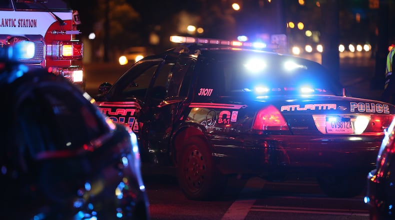 An Atlanta police officer was temporarily trapped after an accident on Spring Street at North Avenue shortly after 9 p.m., police said. BEN GRAY / BGRAY@AJC.COM