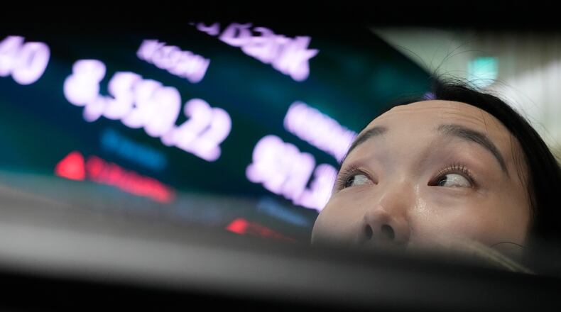 A currency trader watches monitors near a screen showing the Korea Composite Stock Price Index (KOSPI) at the foreign exchange dealing room of the Hana Bank headquarters in Seoul, South Korea, Wednesday, July 1, 2026. (AP Photo/Ahn Young-joon)