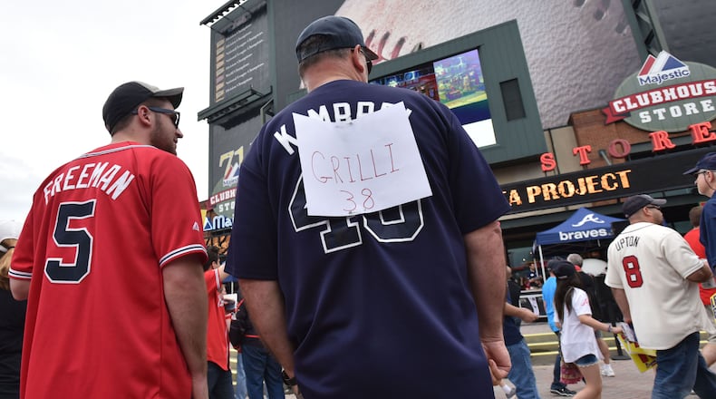 Ayron Dent, of Temple, covers up his Craig Kimbrel jersey shirt with new relief pitcher Jason Grilli (39) before the Atlanta Braves home opener Friday, April 10, 2015, against the New York Mets at Turner Field in Atlanta.