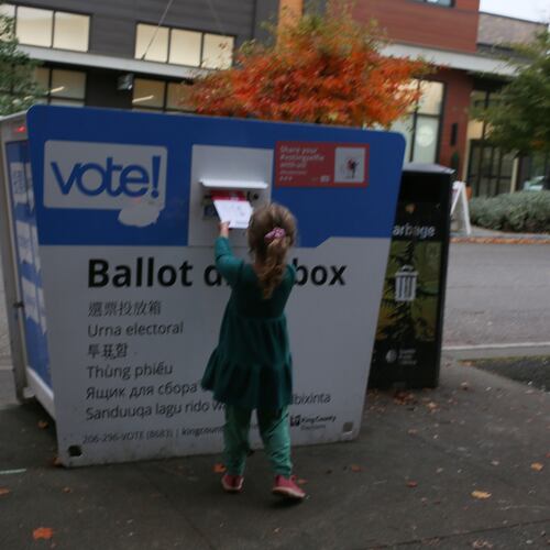 FILE -Olive, 4, deposits an election ballot into a drop box in Seattle, Wash. under the supervision of her mother, on Nov. 4, 2025. (AP Photo/Cedar Attanasio, File)
