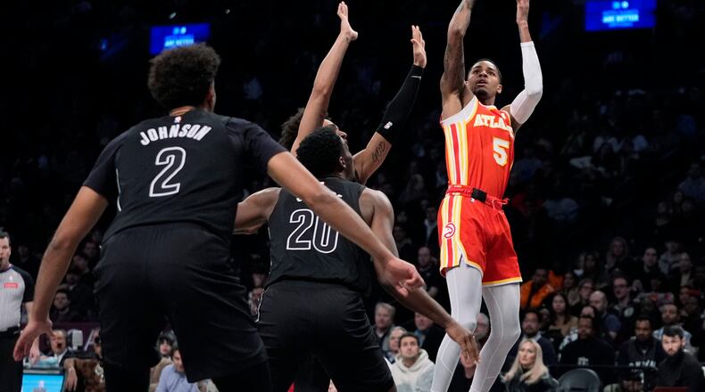 Atlanta Hawks' Dejounte Murray (5) shoots over Brooklyn Nets' Day'Ron Sharpe (20) and Cameron Johnson (2) during the first half of an NBA basketball game Thursday, Feb. 29, 2024, in New York. (AP Photo/Frank Franklin II)