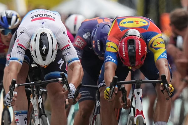 Belgium's Tim Merlier, left, and Italy's Jonathan Milan cross the finish line during the third stage of the Tour de France cycling race over 178.3 kilometers (110.8 miles) with start in Valenciennes and finish in Dunkerque, France, Monday, July 7, 2025. (AP Photo/Thibault Camus)