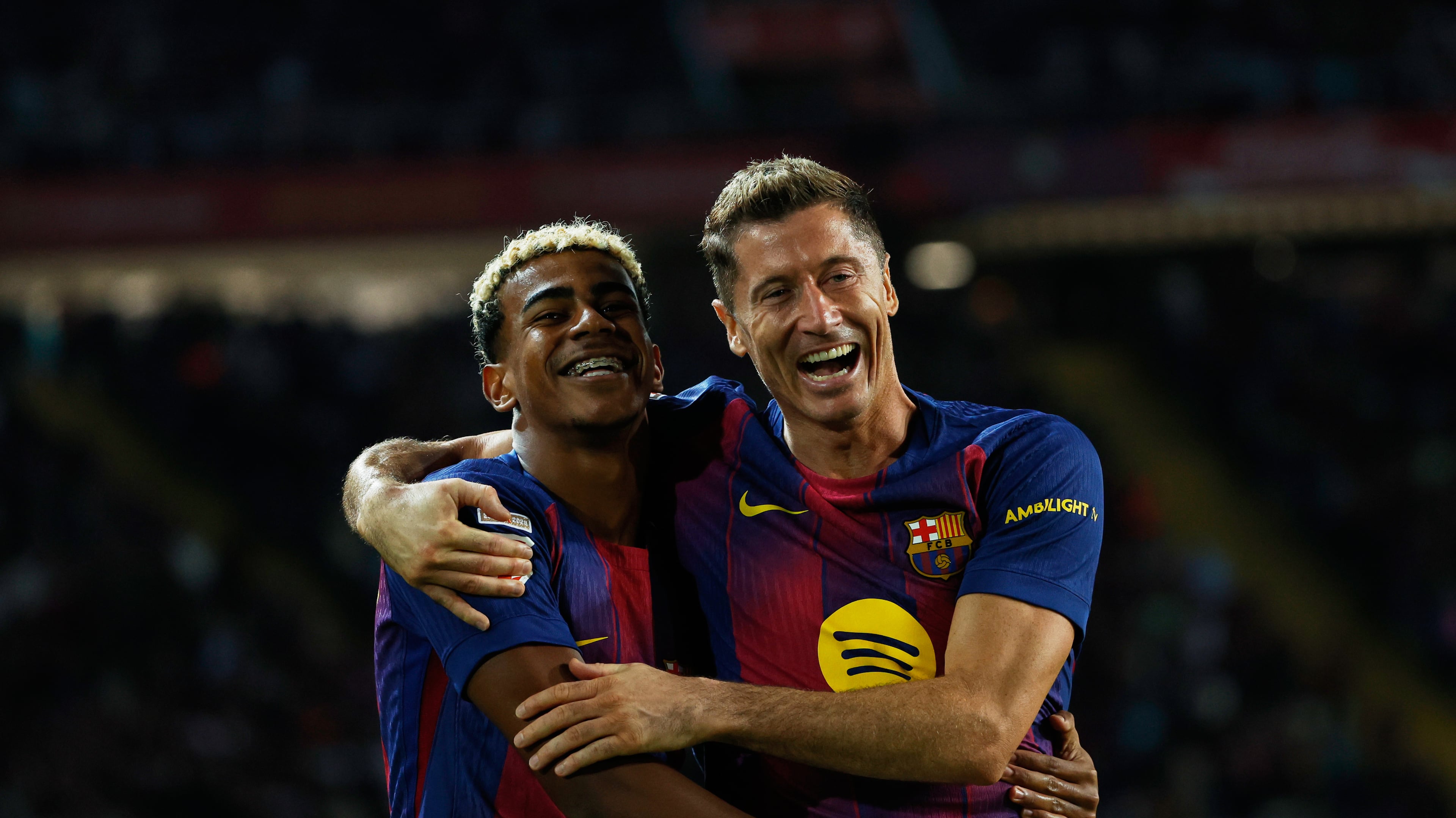 Barcelona's Robert Lewandowski, right, celebrates with Lamine Yamal scoring his side's 2nd goal during a Spanish La Liga soccer match between FC Barcelona and Real Sociedad at the Lluis Companys Olympic Stadium in Barcelona, Spain, Sunday, Sept. 28, 2025. (AP Photo/Joan Monfort)