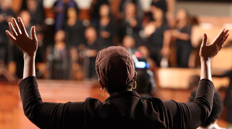 A woman enjoys the music prior to a community forum featuring U.S. Attorney General Eric Holder at Ebenezer Baptist Church on Monday night. BEN GRAY / BGRAY@AJC.COM