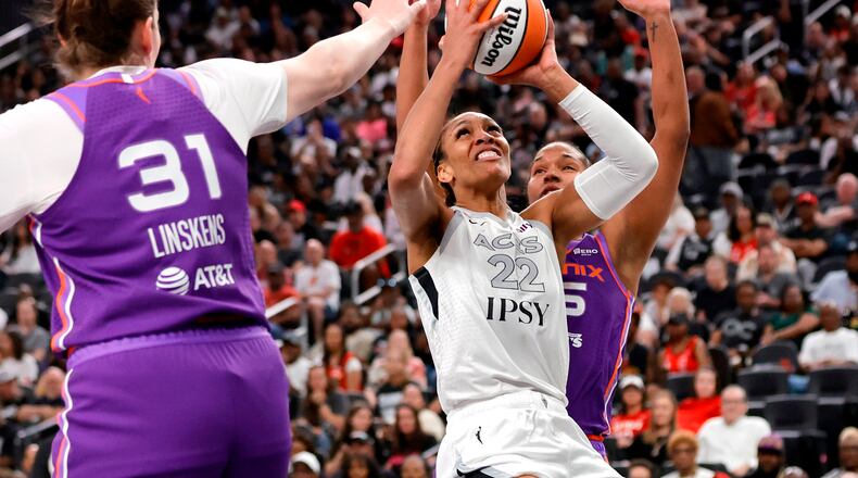 Las Vegas Aces center A'ja Wilson (22) looks to shoot between Phoenix Mercury center Kyara Linskens (31) and forward Alyssa Thomas, right, during the first half of an WNBA basketball game Saturday, May 9, 2026, in Las Vegas. (Steve Marcus/Las Vegas Sun via AP)