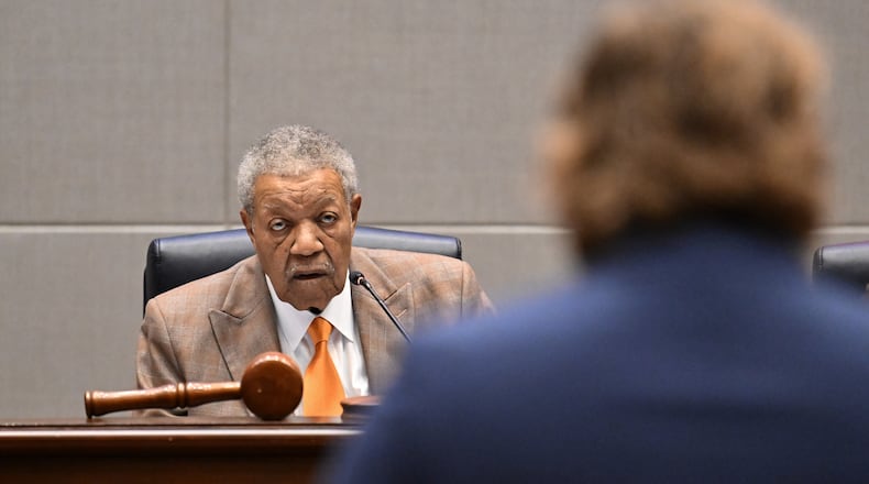 Fulton County Board of Commissioners Chairman Robb Pitts listens as Kyle Gomez-Leineweber (foreground), with Common Cause Georgia, speaks during public comment at the Fulton County Government Center on Wednesday, Feb. 4, 2026, in Atlanta. (Hyosub Shin/AJC)