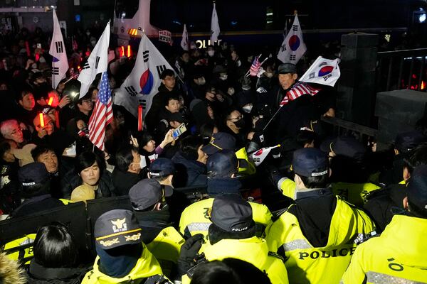 FILE - Police officers stand guard as supporters of impeached South Korean President Yoon Suk Yeol try to enter the Seoul Western District Court in Seoul, South Korea, Saturday, Jan. 18, 2025. (AP Photo/Ahn Young-joon, File)