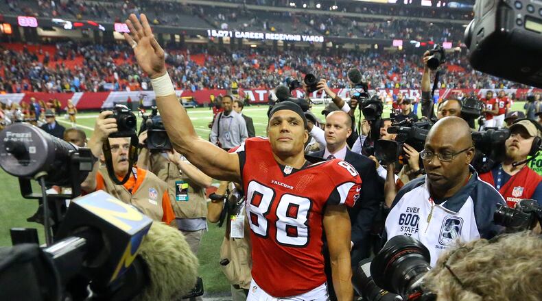 Falcons tight end Tony Gonzalez is surrounded by media as he waves farewell to fans walking off the field after playing his final NFL football game against the Panthers on Sunday, Dec. 29, 2013, in Atlanta.