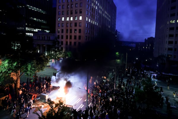 Protestors surround a dumpster that was set on fire in front of the Henry M. Jackson Federal Building during a protest against federal immigration arrests, Wednesday, June 11, 2025, in Seattle. (AP Photo/Ryan Sun)
