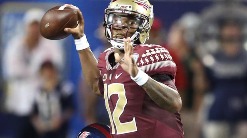 Florida State quarterback Deondre Francois (12) throws while in the grasp of Ole Miss defensive tackle D.J. Jones (behind) during the Florida State vs. University of Mississippi college football game on Monday, Sept. 5, 2016 at Camping World Stadium in Orlando, Fla. (Stephen M. Dowell/Orlando Sentinel/TNS)