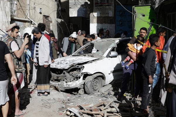 Yemenis watch a damaged vehicle at Farwah popular market, which Houthis said was struck by U.S. airstrikes, in Sanaa, Yemen, Monday, April 21, 2025. (AP Photo)