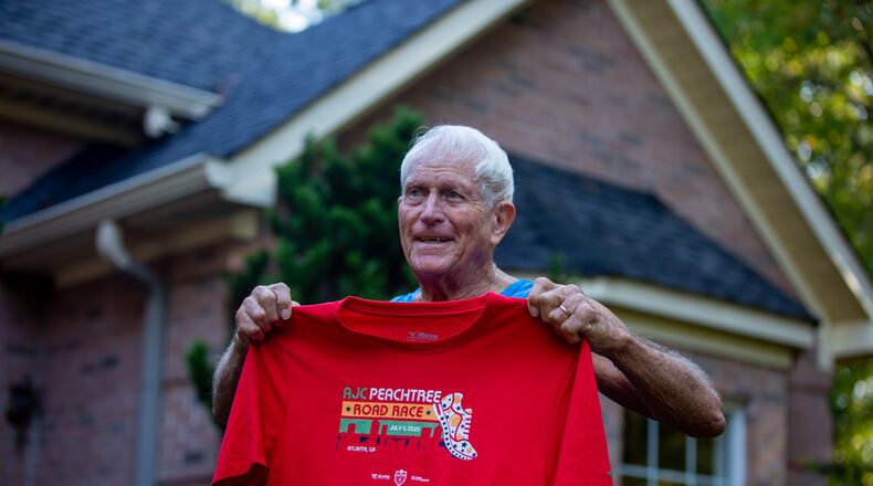 Bill Thorn holds up the Peachtree Road Race t-shirt in Tyrone, Georgia, on October 13. Thorn was presented the t-shirt by the Atlanta Track Club. (Photo/Rebecca Wright for the Atlanta Journal-Constitution)