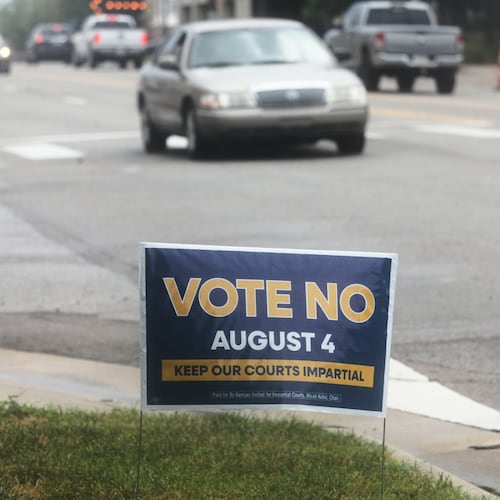 A sign encourages voters to reject a proposal to change how Kanas Supreme Court justices are seated in Topeka, Kan., on Thursday, July 30, 2026. (AP Photo/John Hanna)