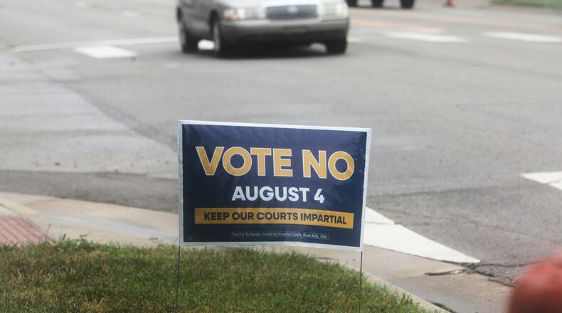 A sign encourages voters to reject a proposal to change how Kanas Supreme Court justices are seated in Topeka, Kan., on Thursday, July 30, 2026. (AP Photo/John Hanna)