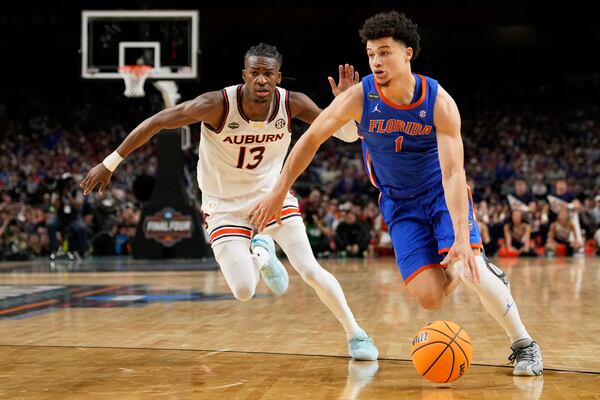 Florida guard Walter Clayton Jr. drives around Auburn guard Miles Kelly during the second half in the national semifinals at the Final Four of the NCAA college basketball tournament, Saturday, April 5, 2025, in San Antonio. (AP Photo/Brynn Anderson)