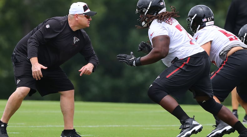Down in the trenches: Offensive line coach Chris Morgan gets in some work with guard James Carpenter during Wednesday's minicamp practice in Flowery Branch. (Curtis Compton/ccompton@ajc.com).