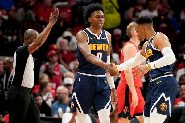 Denver Nuggets forward Peyton Watson, center, celebrates his three point basket with Russell Westbrook during the second half of an NBA basketball game against the Houston Rockets, Sunday, April, 13, 2025, in Houston. (AP Photo/Eric Christian Smith)