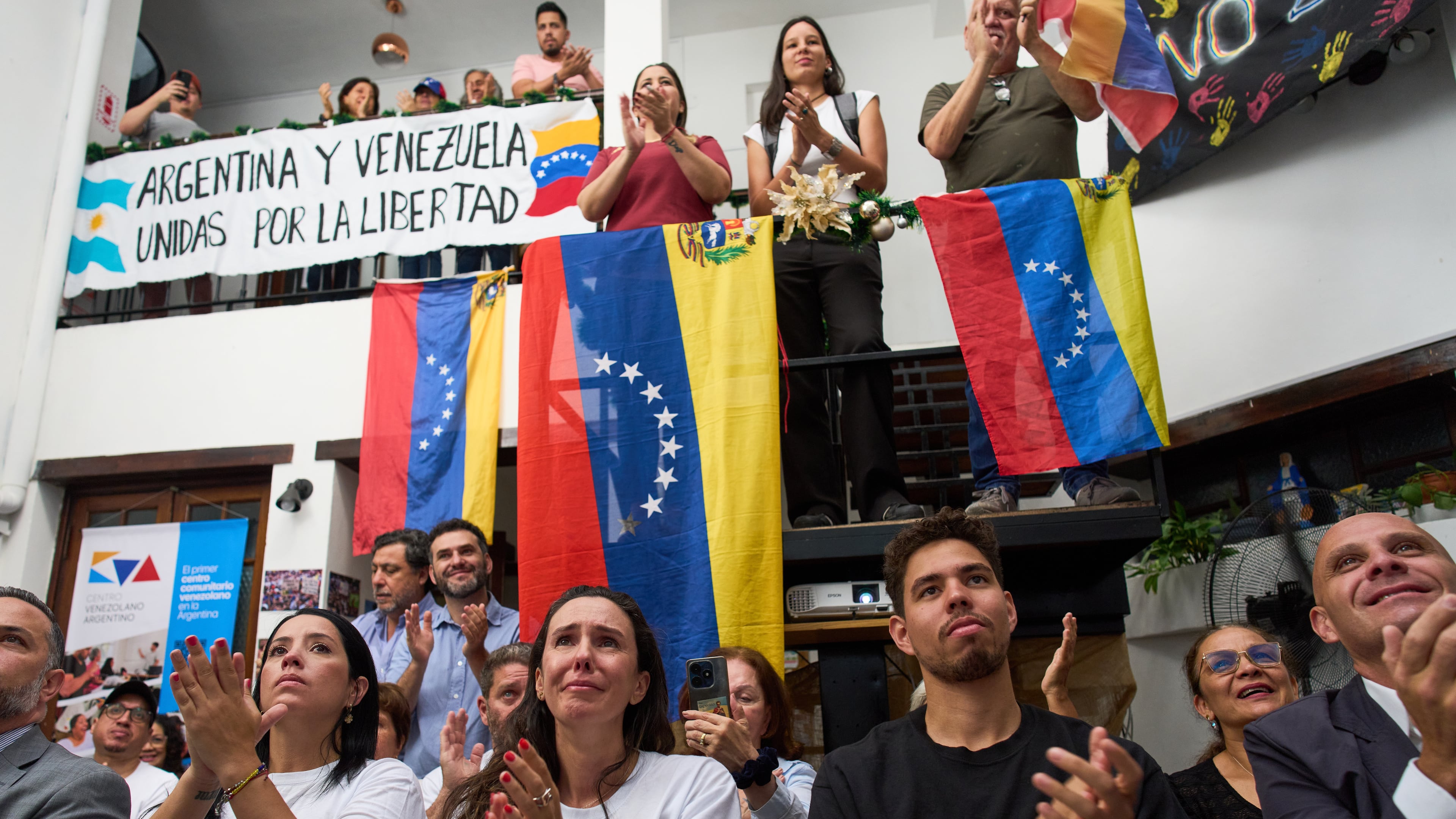 People applaud while watching the ceremony of the Nobel Peace Prize for Venezuelan opposition leader Maria Corina Machado in Norway, during a live viewing in Buenos Aires, Argentina, Wednesday, Dec. 10, 2025. (AP Photo/Rodrigo Abd)