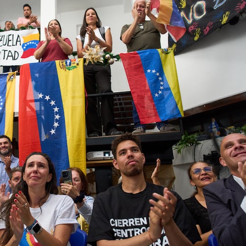 People applaud while watching the ceremony of the Nobel Peace Prize for Venezuelan opposition leader Maria Corina Machado in Norway, during a live viewing in Buenos Aires, Argentina, Wednesday, Dec. 10, 2025. (AP Photo/Rodrigo Abd)