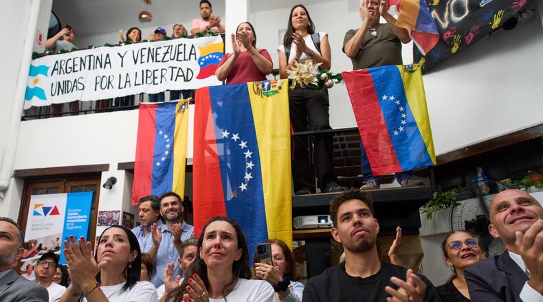 People applaud while watching the ceremony of the Nobel Peace Prize for Venezuelan opposition leader Maria Corina Machado in Norway, during a live viewing in Buenos Aires, Argentina, Wednesday, Dec. 10, 2025. (AP Photo/Rodrigo Abd)