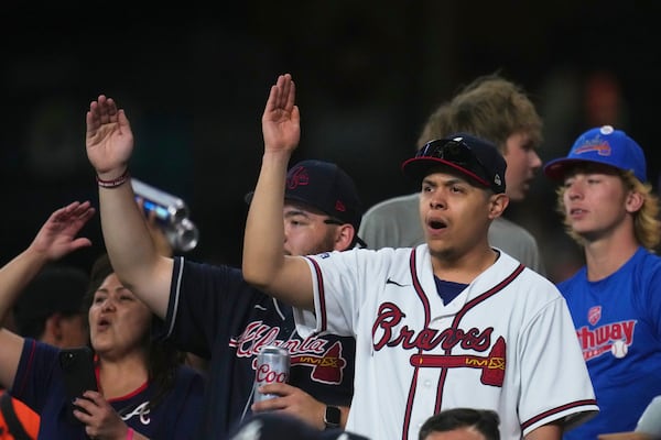 Atlanta Braves fans celebrate a run scored against the Arizona Diamondbacks during the sixth inning of a baseball game Friday, April 25, 2025, in Phoenix. (AP Photo/Ross D. Franklin)