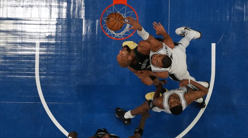 San Antonio Spurs forward Victor Wembanyama (1), right, scores against Minnesota Timberwolves center Rudy Gobert (27) during the first half of Game 4 of an NBA basketball second-round playoffs series, Sunday, May 10, 2026, in Minneapolis. (AP Photo/Abbie Parr)
