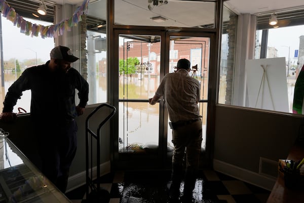 Brandon Sanderson, left, Josh Brashears set up sandbags after flooding in Hopkinsville, Ky., Friday, April 4, 2025. (AP Photo/George Walker IV)
