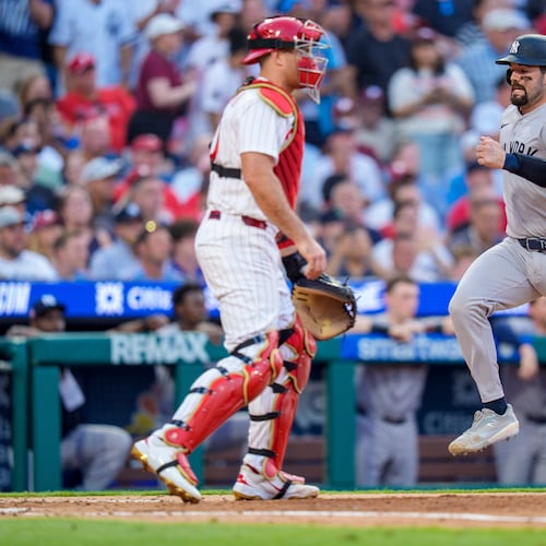 New York Yankees' Austin Wells, right, comes in to score on the single by Cody Bellinger as Philadelphia Phillies catcher J.T. Realmuto, left, looks on during the sixth inning of a baseball game, Saturday, July 25, 2026, in Philadelphia. (AP Photo/Chris Szagola)