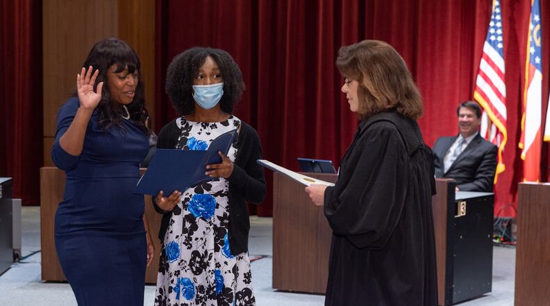 Melody Kelley, Sandy Springs first Black elected official, was sworn into office Tuesday with her daughter, Kiara, holding the oath of office document that she read from aloud.