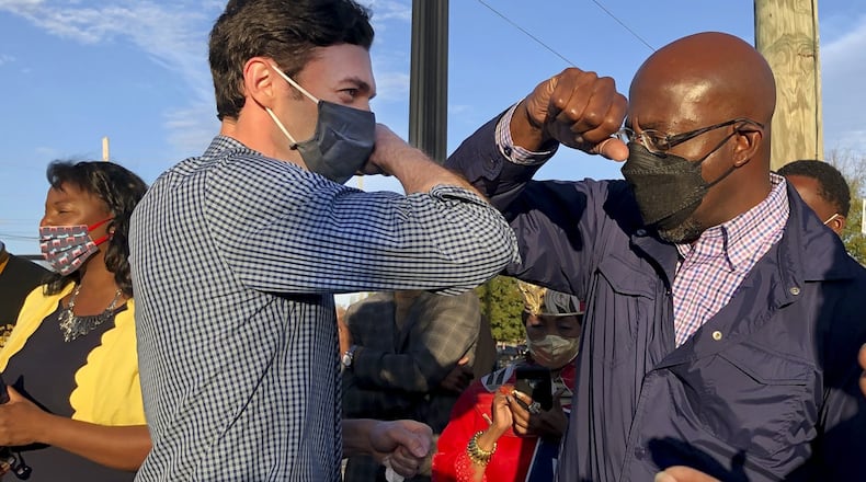 Georgia's Democratic U.S. Senate candidates Jon Ossoff, left, and Raphael Warnock tap elbows during a rally for supporters on November 15, 2020, in Marietta, Georgia. (Jenny Jarvie/Los Angeles Times/TNS)