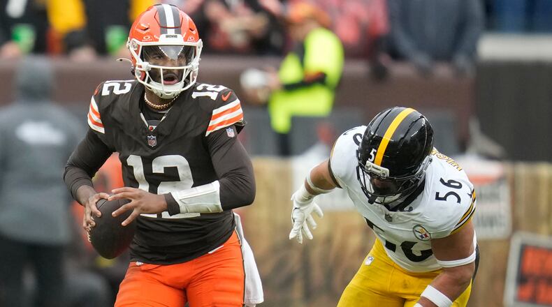 Cleveland Browns quarterback Shedeur Sanders (12) runs from Pittsburgh Steelers linebacker Alex Highsmith (56) during the second half of an NFL football game, Sunday, Dec. 28, 2025, in Cleveland. (AP Photo/Sue Ogrocki)