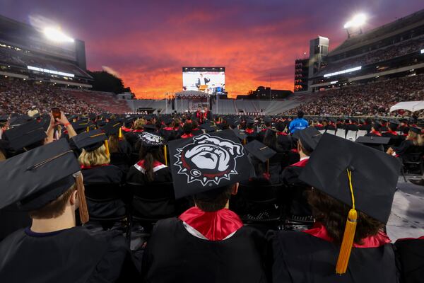 The sun sets as University of Georgia graduates listen during the commencement address by DJ Shockley at the spring undergraduate commencement ceremony at Sanford Stadium on Friday, May 8, 2026, in Athens. (Jason Getz/AJC)