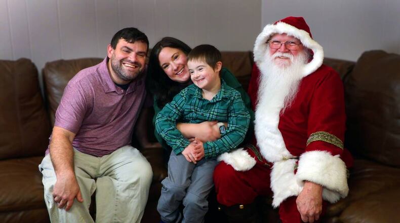 Carrie and Michael Defenbaugh pose with their 8-year-old son Grayson and the Santa Claus who helped end the frantic search, Stephen Coggins (right).
(Photo Courtesy of Mike Haskey)