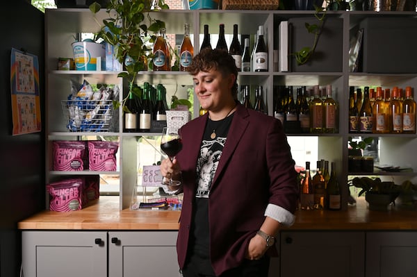 Jett Kolarik swirls a glass of wine at Side Saddle Wine Saloon and Bar in Atlanta on Thursday, June 18, 2026. Kolarik, who is currently the sommelier at Koshu Club, helped start the wine program at Side Saddle. (Hyosub Shin/AJC)