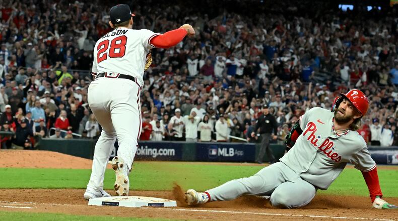 Atlanta Braves first baseman Matt Olson (28) forces out Philadelphia Phillies designated hitter Bryce Harper (3) after Philadelphia Phillies right fielder Nick Castellanos filed into a double play to end the ninth inning in the Game 2 of the 2023 National League Division Series at Truist Park, Monday, October 9, 2023, in Atlanta. Atlanta Braves won 5-4 over Philadelphia Phillies. (Hyosub Shin / Hyosub.Shin@ajc.com)
