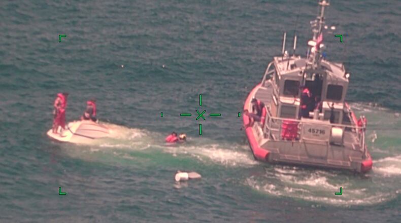 In this photo released by the U.S. Coast Guard, members of the Coast Guard rescue a family of four Wednesday from a vessel taking on water 17 miles south of Southwest Pass near Venice, Louisiana.