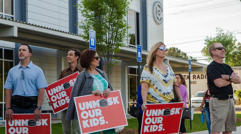Protesters outside of the Cobb County School District office show their opposition to masking children in Cobb County schools for the upcoming school year on Thursday, May 20, 2021, in Marietta, Georgia . Many community members waited in line to speak at the school board meeting to voice their support for unmasking.  CHRISTINA MATACOTTA FOR THE ATLANTA JOURNAL-CONSTITUTION