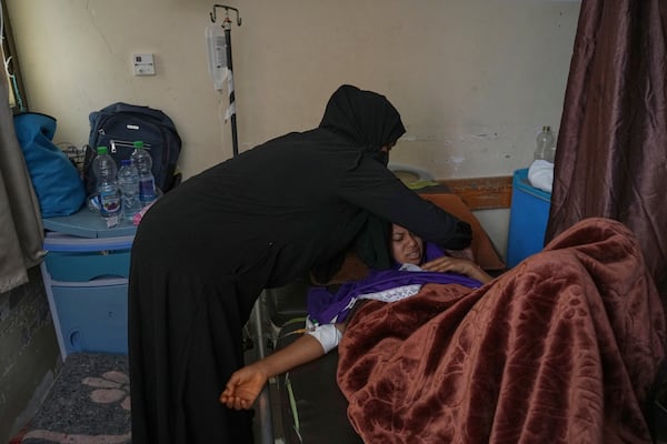 Salwa Faraj cares for her sister, Asmaa Faraj, who was injured in an Israeli army strike, at Nasser Hospital in Khan Younis, Gaza Strip, Tuesday, May 6, 2025. (AP Photo/Abdel Kareem Hana)