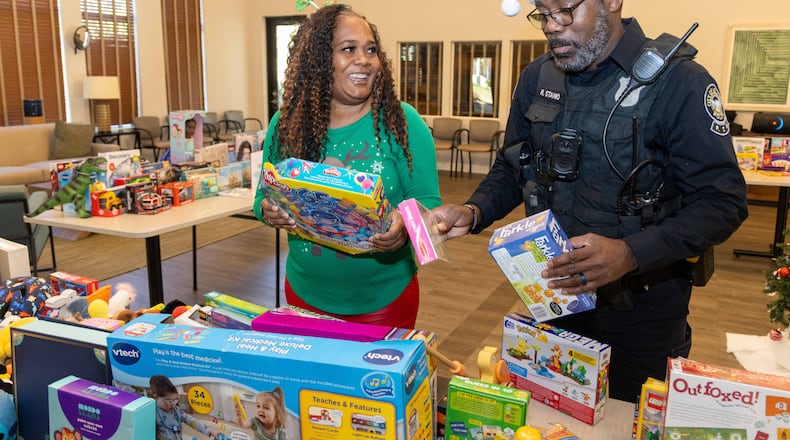 Event coordinator Shacole Pearman and Atlanta Police Officer Russel Stanio prepare gifts for kids in the Amani Place Apartment Homes community Center.
PHIL SKINNER FOR THE ATLANTA JOURNAL-CONSTITUTION